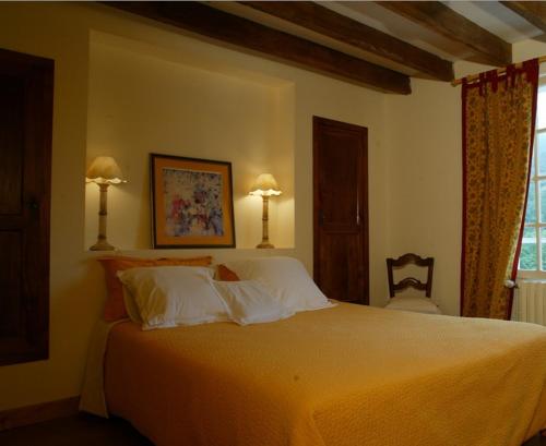 1 dormitorio con 1 cama grande con almohadas blancas en Chambres d'Hôtes Oyhanartia, en Larceveau-Arros-Cibits