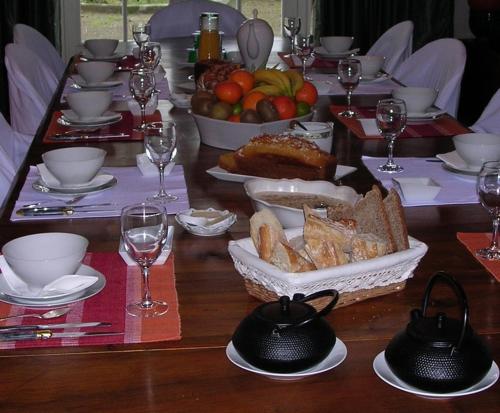 - une table en bois avec un ensemble de plats et de verres à vin dans l'établissement Chambres d'Hôtes Oyhanartia, à Larceveau-Arros-Cibits
