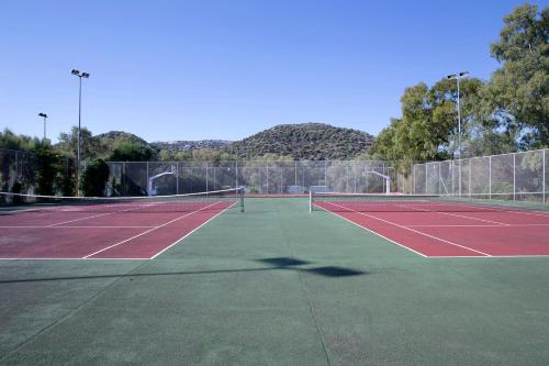a tennis court with two tennis rackets on it at Dolce by Wyndham Athens Attica Riviera in Vravrona