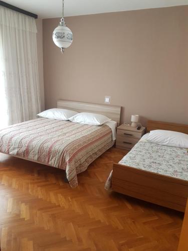 a bedroom with two beds and a chandelier at Guest House Mrvčić in Rupa