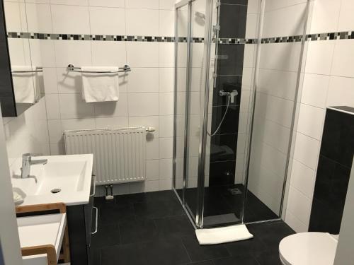 
a bathroom with a toilet, sink, and shower stall at Hotel Bellini in Leoben
