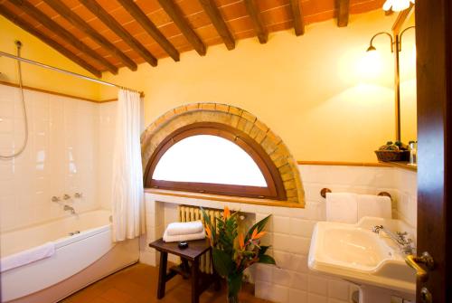 a bathroom with a sink and a tub and a window at Monsignor Della Casa Country Resort & Spa in Borgo San Lorenzo