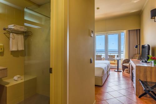 a hotel room with a bed and a bathroom at Calheta Beach - All-inclusive - Savoy Signature in Calheta