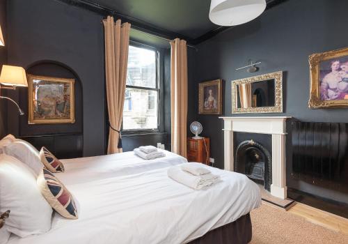 een slaapkamer met een groot bed en een open haard bij The Castle Esplanade Residence in Edinburgh