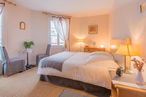 - une chambre avec un grand lit, un bureau et une chaise dans l'établissement Chambres d'hôtes La Maison Hippolyte, à Paris