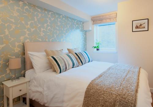 エディンバラにあるThe Drummond Street Residenceのベッドルーム1室(青い壁の白いベッド1台付)