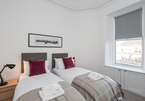 1 Schlafzimmer mit 2 Betten und einem Fenster in der Unterkunft The Brunswick Street Residence in Edinburgh