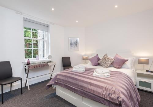 - une chambre avec un lit, un bureau et une fenêtre dans l'établissement Castle Suite 1 Old Town, à Édimbourg
