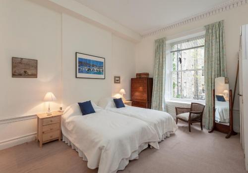 een slaapkamer met een bed, een stoel en een raam bij The Hart Residence in Edinburgh