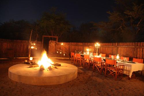 a fire pit in a yard with a table and chairs at Vuyani Safari Lodge in Hoedspruit