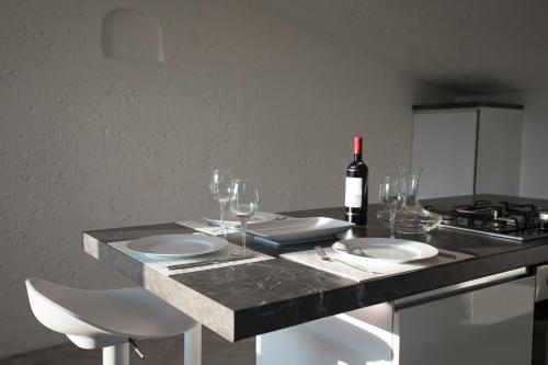 a table with two white plates and a bottle of wine at Rooftop Apartment in Garda