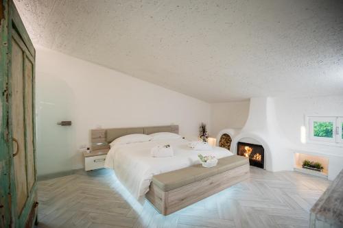 a white bedroom with a bed and a fireplace at Rooftop Apartment in Garda