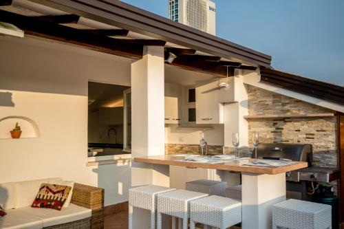 an outdoor kitchen with a counter and stools at Rooftop Apartment in Garda