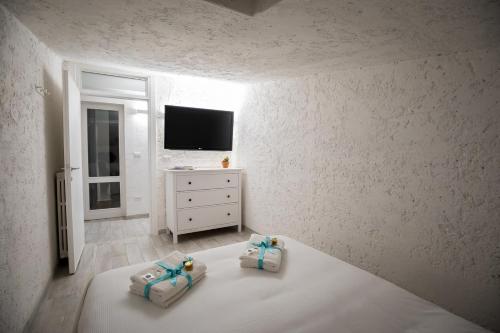 a white bedroom with two pillows on a bed at Rooftop Apartment in Garda