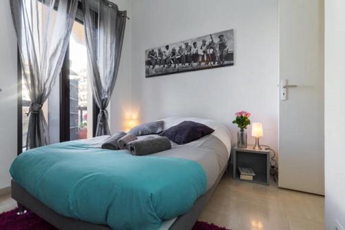 une chambre avec un grand lit avec des oreillers bleus dans l'établissement GRAND H -F2, FACE VIEUX- NICE, TERRASSE, ASCENSEUR, CLIMATISATION, Terrace - Nice city center, à Nice