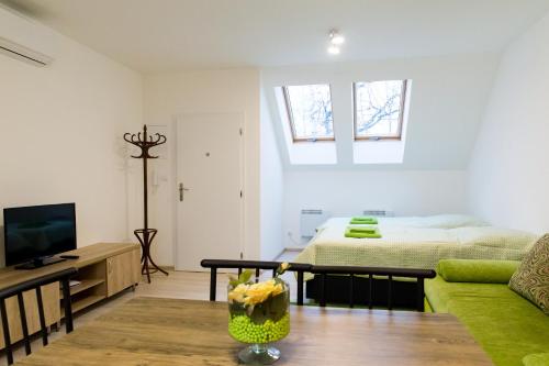 a living room with a green couch and a bed at Apartmány pre Vás in Levice