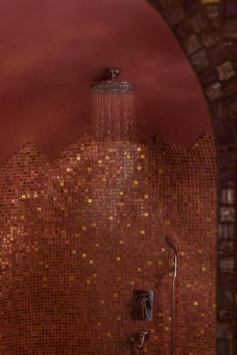 a bathroom with a chandelier hanging from a brick wall at Anteliz Suites in Fira