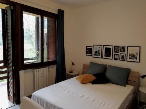 - une chambre avec un lit blanc et une fenêtre dans l'établissement Bianca Studio, à Guanzate