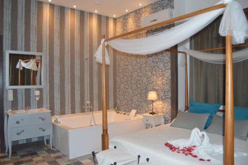 a bedroom with a bed and a tub and a bed and a bed at Balcones de Bentomiz in Vélez-Málaga