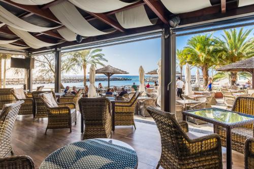 a patio area with tables, chairs and umbrellas at Calheta Beach - All-inclusive - Savoy Signature in Calheta