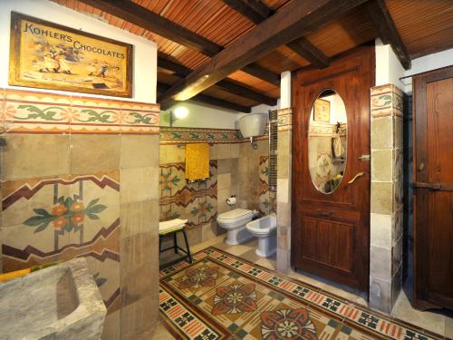 a bathroom with a toilet and a wooden door at La Canonica dei Fiori - Anna Fendi Country House in Ronciglione