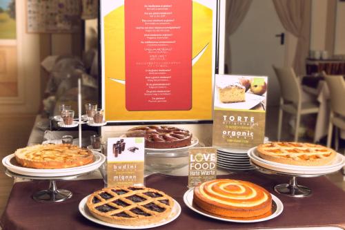 a table with pies and other desserts on plates at eco Hotel Milano & BioRiso Restaurant in Milan