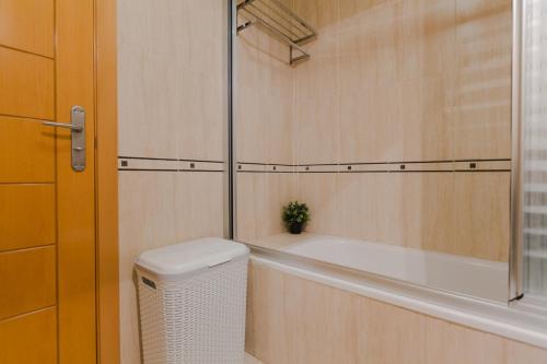 ein Bad mit einer Badewanne und einem Abfallkorb in der Unterkunft Precioso Apartamento la Marina in Rincón de la Victoria