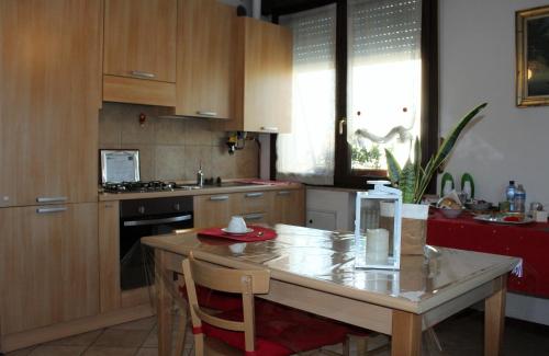 eine Küche mit Holzschränken und einem Tisch mit Stühlen in der Unterkunft B. & B. NABUCCO in Parma