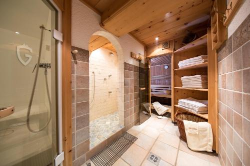 ein Bad mit einer Dusche und einer ebenerdigen Dusche in der Unterkunft Haus Gollas in Sankt Anton am Arlberg