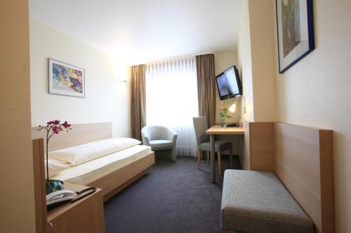 a hotel room with a bed and a desk at City Partner Hotel Berliner Hof in Karlsruhe