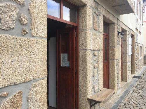 uma porta para um edifício com um banco ao lado em Casas do Terreiro em Seia