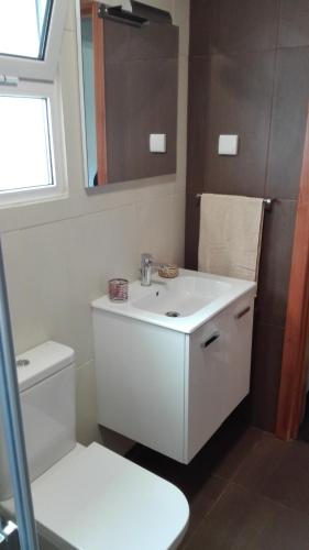 a bathroom with a white sink and a toilet at Casa do Galante in Nordeste