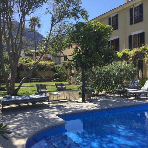 a swimming pool with chairs and a building at The Salvia - Adults Only in Sóller