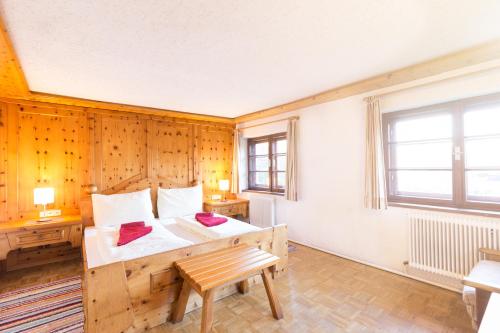 a bedroom with a bed and a wooden wall at Gasthof St. Hubertus in Gschnallenhof