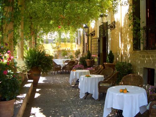 a patio with white tables and chairs and plants at The Salvia - Adults Only in Sóller