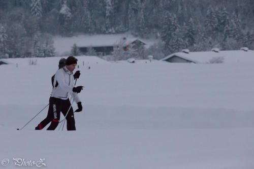 a woman on skis walking through the snow at DEVA Hotel Kaiserblick in Reit im Winkl