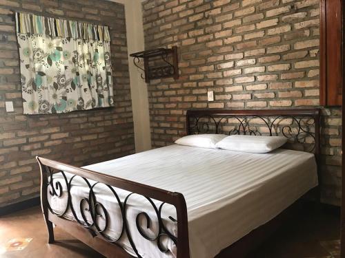 a bed in a room with a brick wall at Sítio do Bosco Park in Tianguá