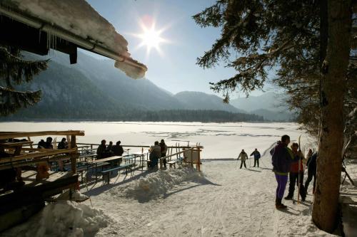 a group of people standing on a pier in the snow at DEVA Hotel Kaiserblick in Reit im Winkl