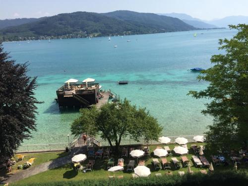 a large boat in the water next to a beach at Hotel Attersee in Seewalchen