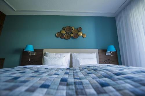 a bedroom with a bed with a blue wall at Boutiquehotel Wörthersee - Serviced Apartments in Velden am Wörthersee