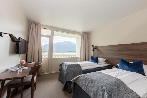 ein Hotelzimmer mit 2 Betten und einem Fenster in der Unterkunft Kviknes Hotel in Balestrand