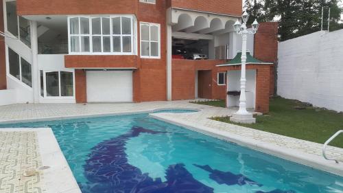 a swimming pool in front of a house at Hostal Mallorca Boutique in Cali