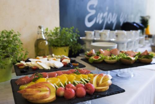 a buffet with three plates of food on a table at Campanile Lublin in Lublin