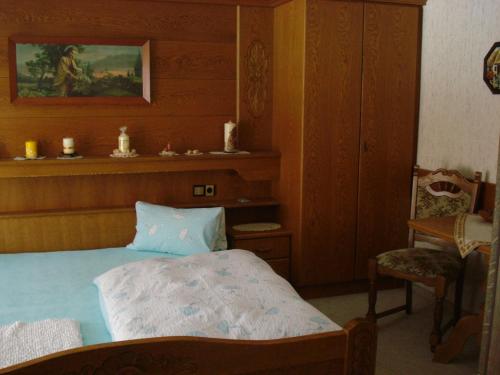 ein Schlafzimmer mit einem Bett und einem Stuhl in der Unterkunft Haus Walter in Nesselwängle