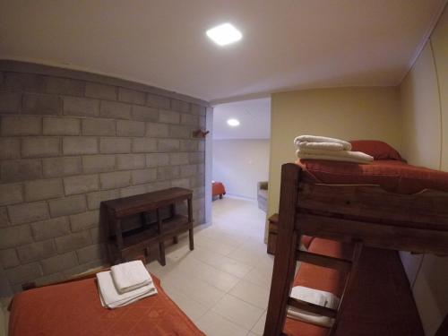 a room with two bunk beds and a hallway at Hostel Los Pioneros in El Calafate
