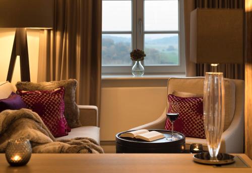 a room with a table and a chair and a window at Hotel Brunnenhaus Schloss Landau in Bad Arolsen