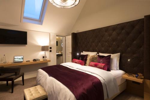 a hotel room with a large bed with red pillows at Hotel Brunnenhaus Schloss Landau in Bad Arolsen
