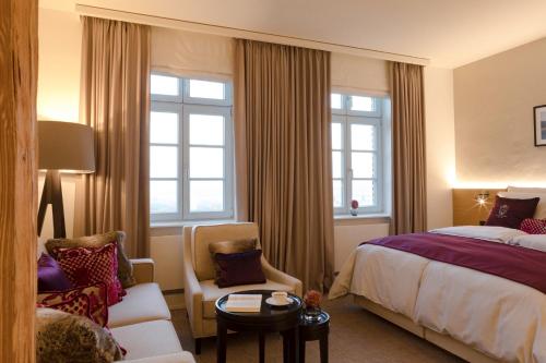 a hotel room with a bed and a chair at Hotel Brunnenhaus Schloss Landau in Bad Arolsen