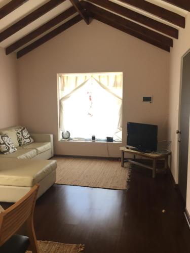 ein Wohnzimmer mit einer Couch und einem Fenster in der Unterkunft Casa Familiar La Serena in La Serena