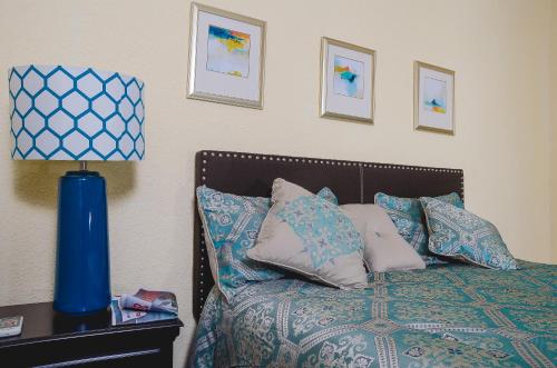 Una cama con almohadas y una lámpara azul en una mesa. en The Bellagio Getaway, en Kingston